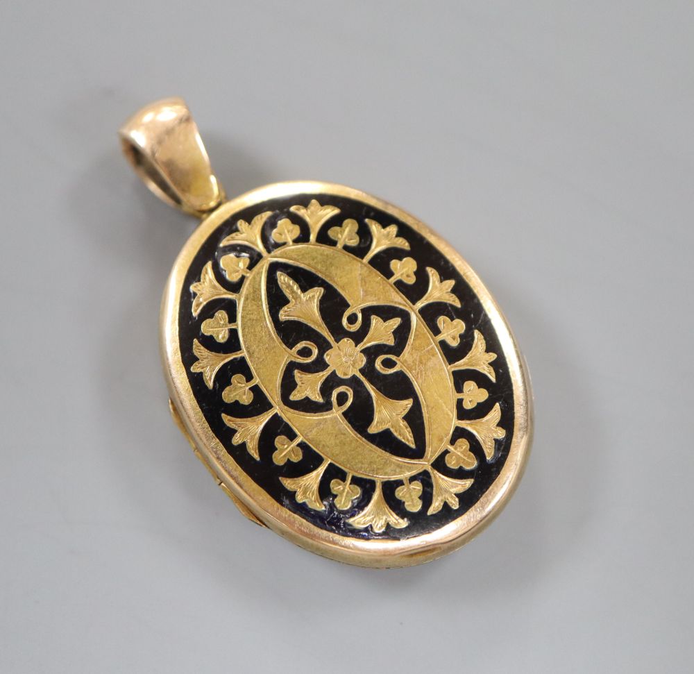 A Victorian engraved yellow metal and black enamel oval mourning locket, 3cm, gross 9.9 grams.